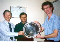 President Keith Levin presents Chris Wylie and Farouk Ahmed with the President's Shield in 1991 for their 1990 flight to Le Touquet. 